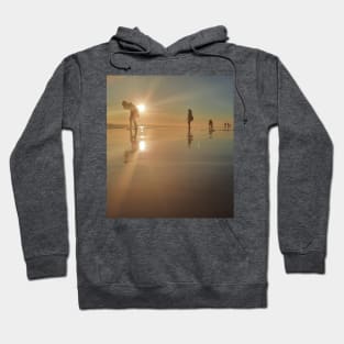 Silhouetted people in a row on a sand beach. Hoodie